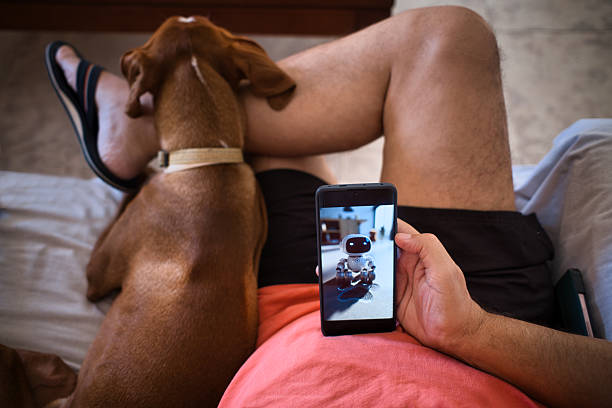 istock Man interacting with AI technology while spending time with pet dog indoors 2229665495
