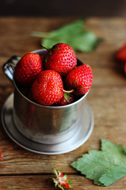strawberries in a metal bucket on the table