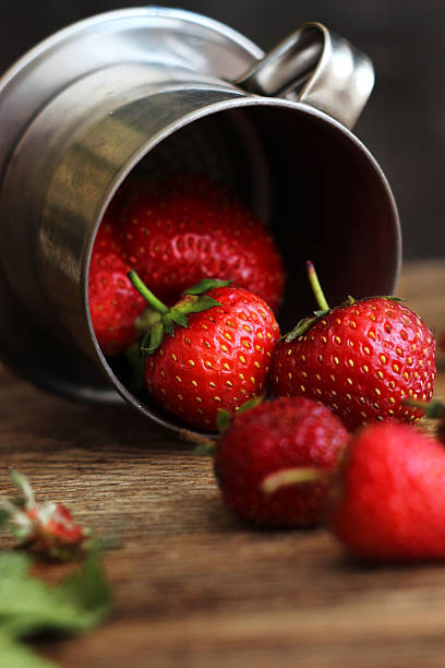strawberries in a metal bucket on the table