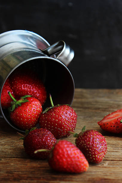 strawberries in a metal bucket on the table