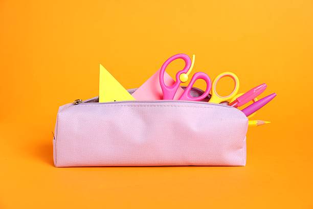 Different stationery in pencil case on orange background