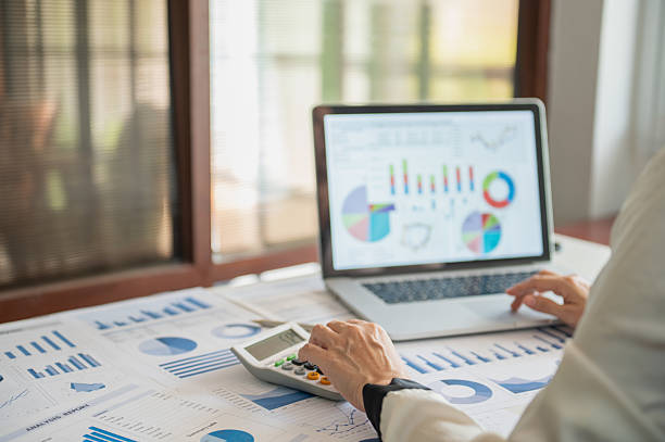 accountant using calcualtor with review accounts report and using digital accounting program software on computer for working accounting standards system at office. stock photo