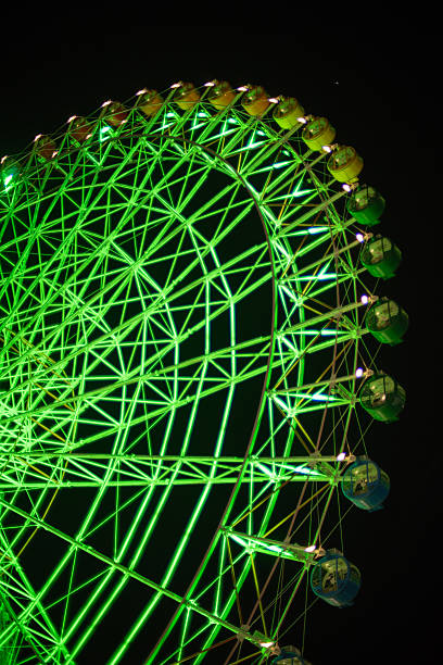istock Illuminated green Ferris wheel against dark night sky 2229667811