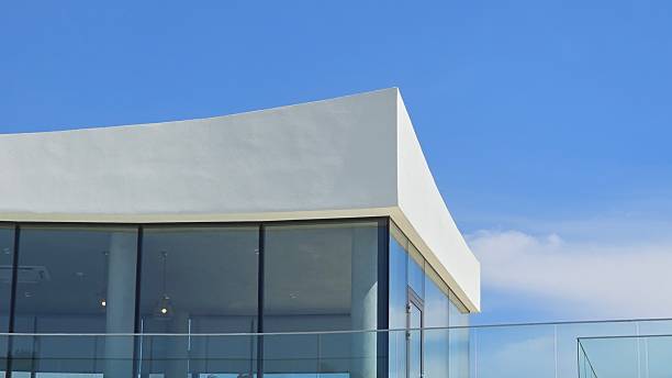 istock Modern white building with glass facade under clear blue sky 2229670165