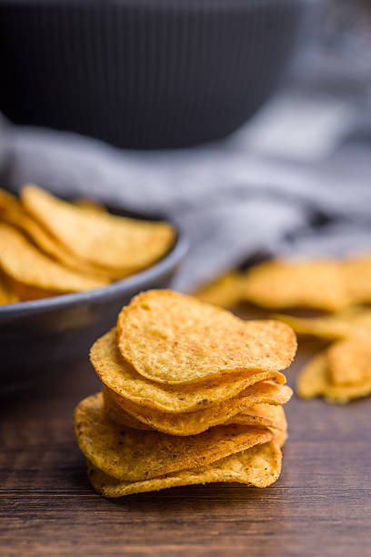 istock Crispy potato chips on wooden table. 2229670307