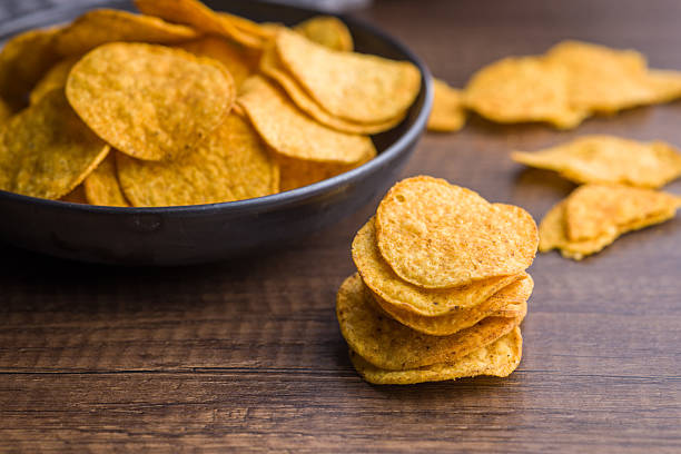 istock Crispy potato chips on wooden table. 2229670537