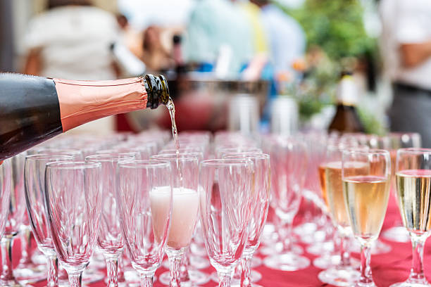 istock Waiter pouring champagne wine while people celebrating important event on the background - Wedding catering and beverage life style concept 2229676005