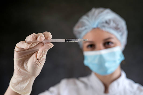 istock female doctor in uniform holding syringe isolated 2229676831