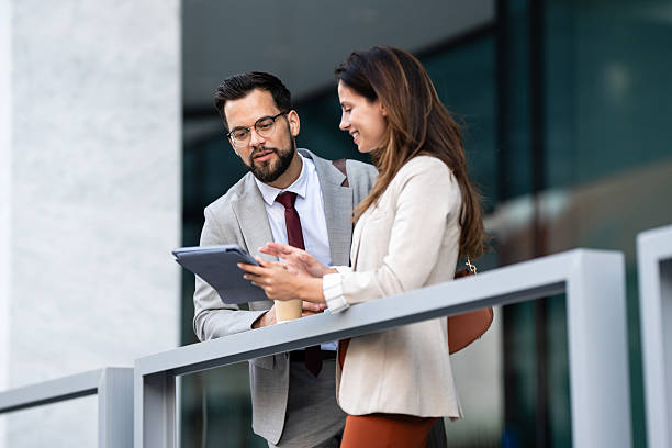 istock Business colleagues using tablet and discussing work outdoors 2229679049