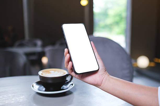 istock Mockup image of a woman holding and using mobile phone with blank desktop screen in cafe 2229679597