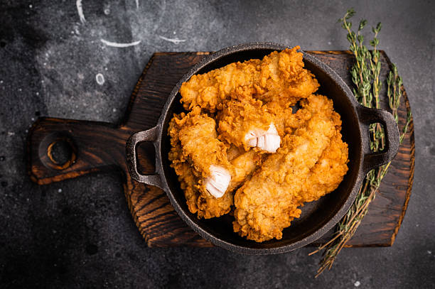 Fried chicken fillet tender strips. wooden background. top view