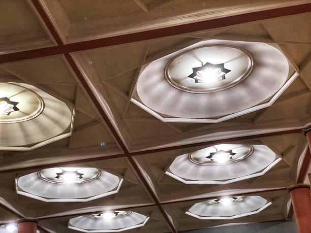 istock A pattern of octagonal ceiling lights with star motifs, creating a modern, geometric look. The warm glow contrasts with the brown and gray tones of the ceiling tiles. 2229680884