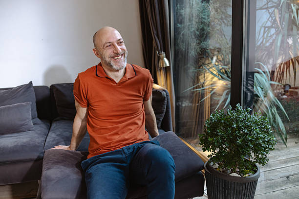 istock Mid adult smiling man sitting on a sofa 2229682207