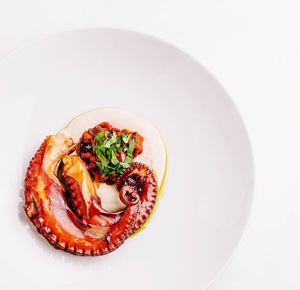 istock Delicious seafood dish featuring octopus with sauce and herbs on white plate 2229682572