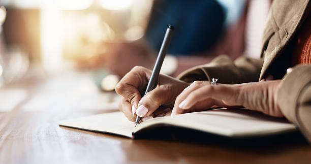 istock Business person, hands and writing with book for reminder, schedule or taking notes in office. Closeup, employee or event planner with pen, notebook or diary for ideas, agenda or tasks in workplace 2229683318