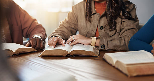 istock Hands, reading and group for Bible study, worship or people learning gospel for religion. Faith, Christianity and knowledge about God, scripture or theology text for guidance with spiritual growth 2229683333