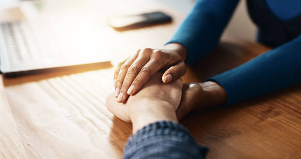 istock Help, holding hands and support with people in home together for bonding, confession or love. Empathy, hope and solidarity with friends at table in apartment for patience, sympathy or understanding 2229683354