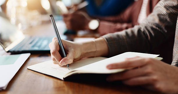 istock Business person, hands and writing with diary for reminder, schedule or taking notes in office. Closeup, employee or event planner with pen, book or ideas for planning, agenda or tasks in workplace 2229683373