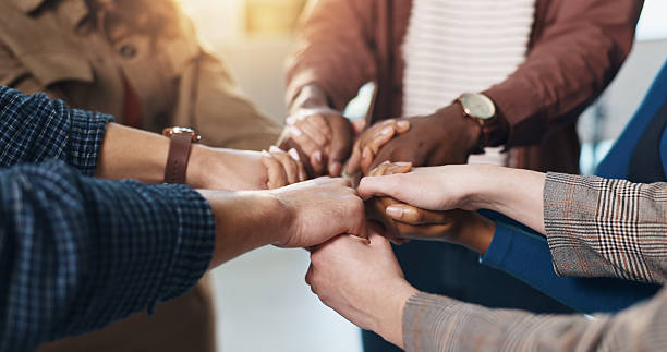 istock Holding hands, community and group of people in unity for support, help and solidarity at therapy. Men, women or counseling for sharing, prayer and trust with commitment and respect in meeting 2229683543