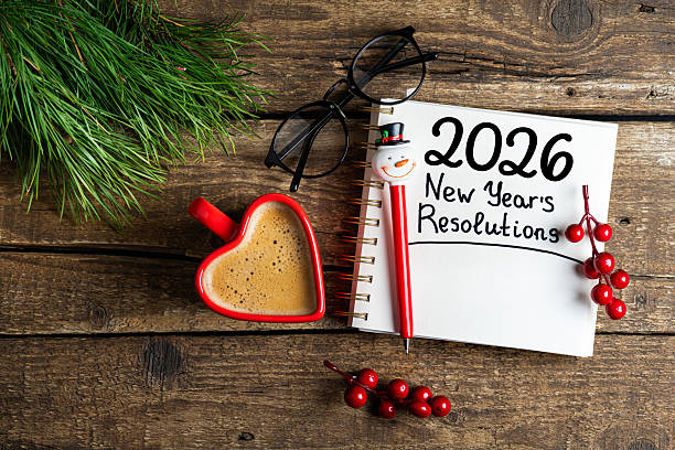 New year resolutions 2026 on desk. 2026 goals list with notebook, coffee cup on wooden table. Resolutions, plan, goals, action, checklist, idea concept. New Year 2026 resolutions