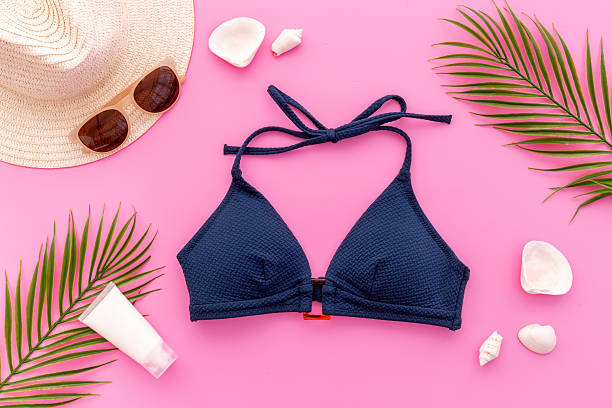 istock Bikini swimsuit with and palm leaves with beach accessories. Flat lay, top view 2229695249