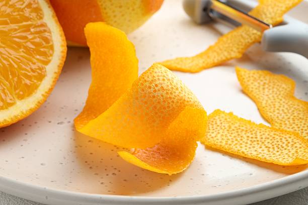 istock Fresh orange peel, fruit and peeler on table, closeup 2229704428