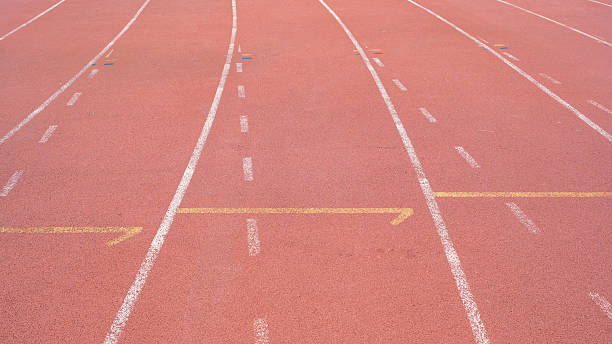 istock Image features close up view of running track with distinct lanes marked by white lines on red surface. track appears well maintained, inviting athletes to engage in training or competition 2229704909