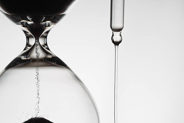 istock Backlit Hourglass with Falling Sand and dropper with drops of serum 2229707542