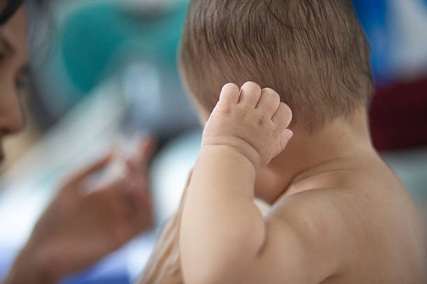 An old woman's hand loves the baby. The concept of family and love