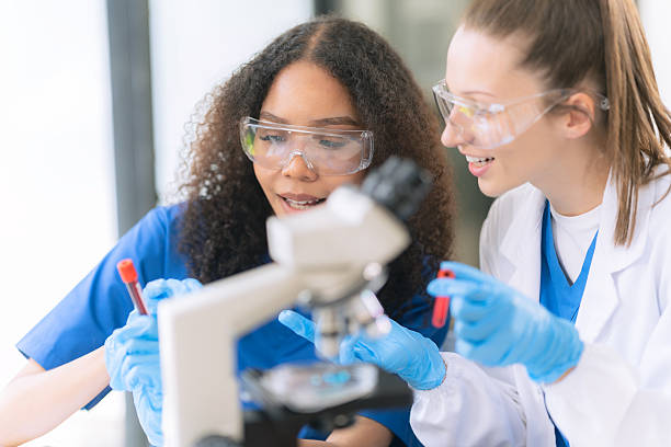 istock Science concept. Two female doctors are conducting research, studying substances under a microscope in a modern medical laboratory. 2229720105