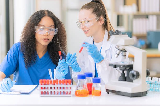 istock Science concept. Two female doctors are conducting research, studying substances under a microscope in a modern medical laboratory. 2229720113