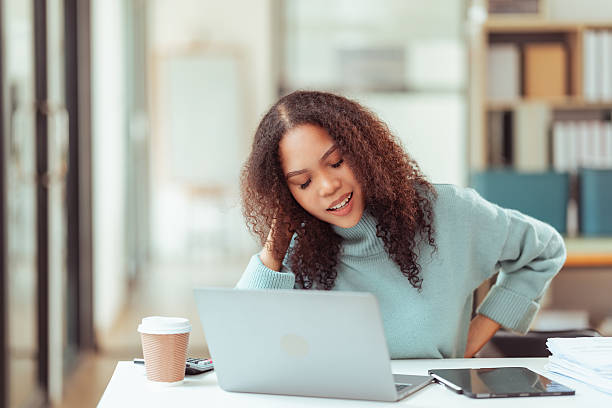 istock Young African American woman using digital tablet and laptop creative design working in office 2229720163