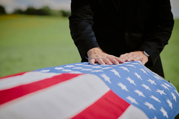 istock Middle Aged Caucasian Man Mourning at Flag Draped Casket during Funeral Ceremony 2229720564