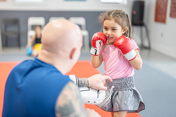 istock Young Girl Learns Boxing Techniques With Trainer in a Gym Setting 2229726540