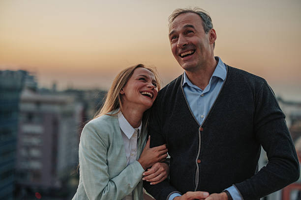 istock Couple laughing together on a rooftop at sunset 2229728648