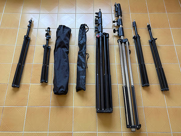Tripods lined up on the flooring. Photographer or videographer equipments for lighting. Photo studio equipments. Tripods for lamp or camera