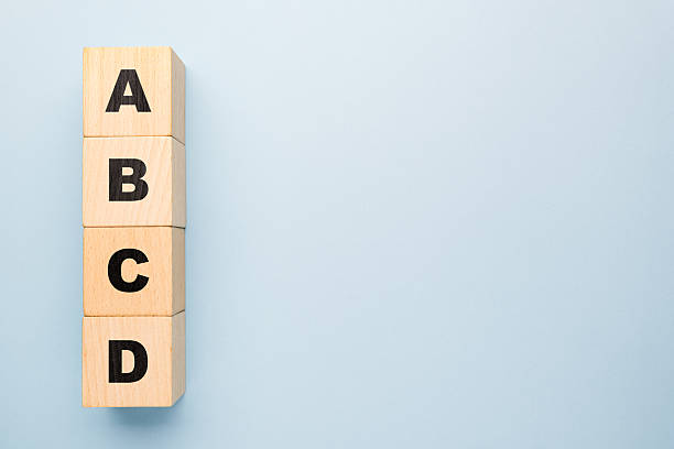 istock Wooden blocks stacked vertically with letters A B C D on light blue background 2229729261