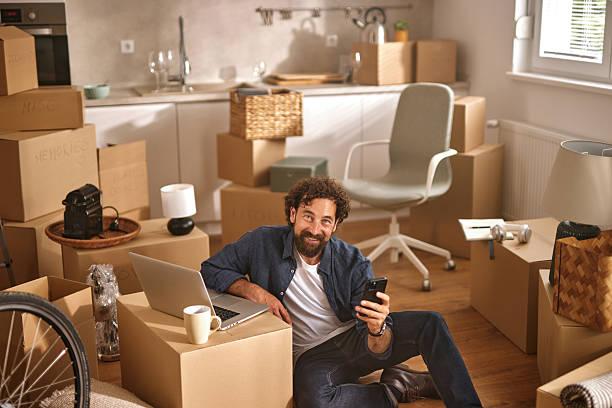 istock Man relaxing on the floor using smartphone in new home 2229731890