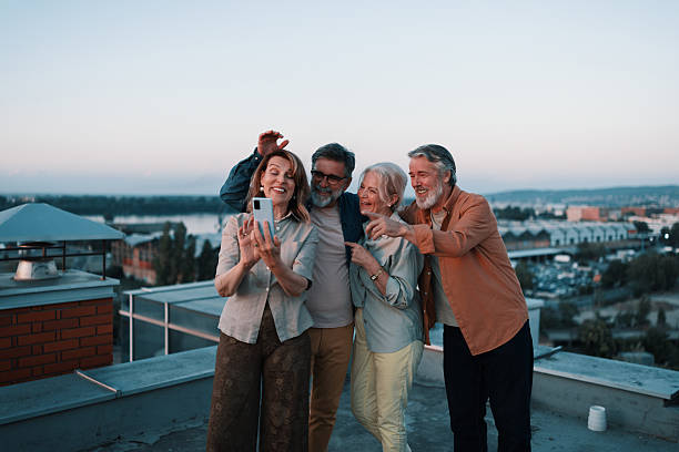 istock Two elderly couples capturing rooftop sunset memories together 2229735502