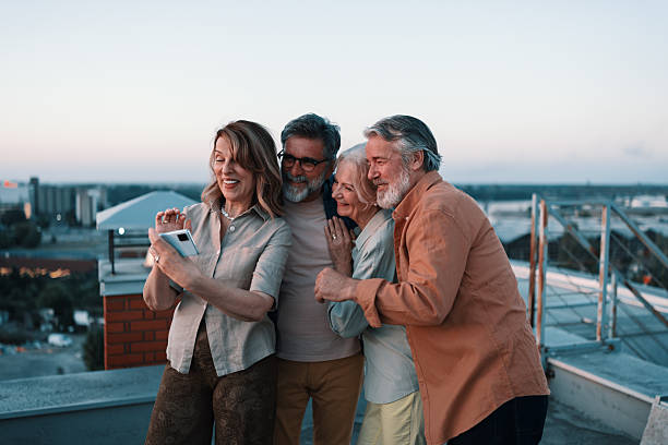 istock Seniors laughing together during rooftop sunset gathering 2229735534