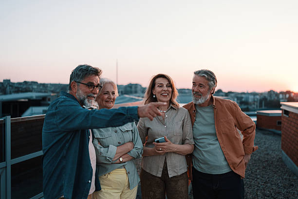istock Senior friends enjoying sunset on rooftop 2229735573