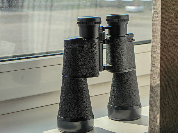 istock Black binoculars on a windowsill, providing a close-up of the optics. 2229737227