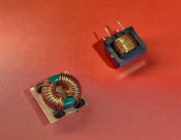istock Inductors and transformers on a red background, showcasing electronic components. 2229737350