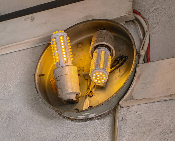 istock Bright LED light bulbs illuminate a worn, vintage light fixture on a textured wall, creating a warm, inviting glow. 2229737407