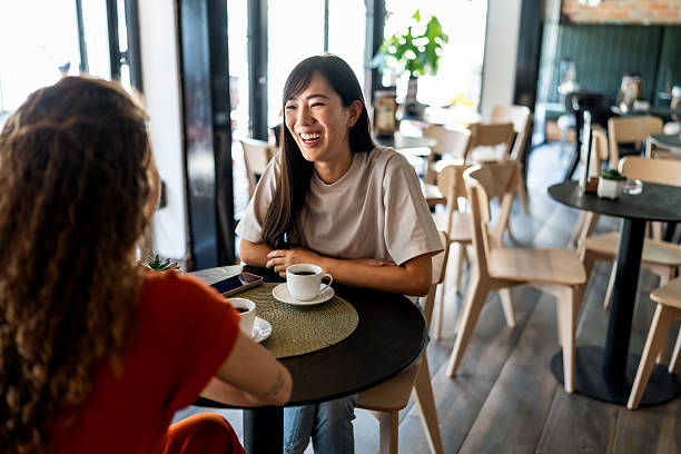 istock Two young women talking and drinking coffee in a cafe 2229739468