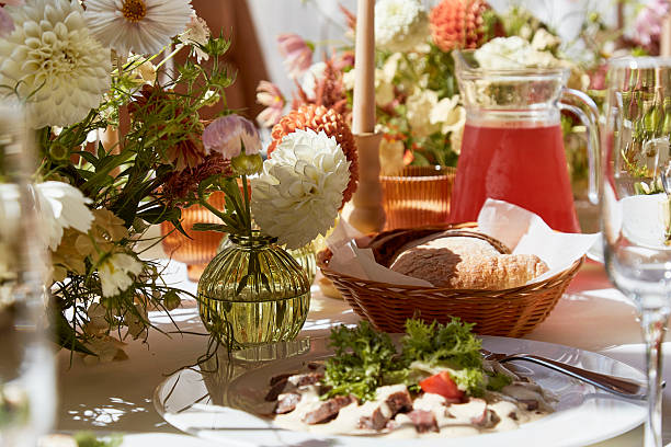 istock Restaurant summer aesthetics table setting, flowers arrangement under sunlight shadows. Cozy setup with flowers and candles 2229739703