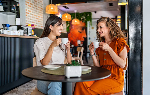 istock Two young women enjoying coffee and conversation in cafe 2229740799
