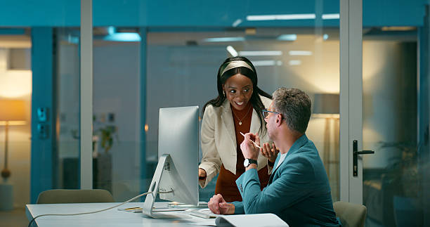 istock Computer, colleagues and people with ideas, office and investment strategy on website or discussion. Financial analyst, man and woman with tech, working late and plan for funding opportunity at night 2229745685