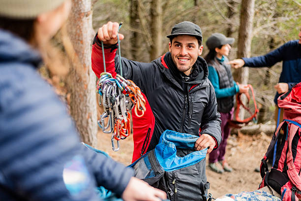 Young man adjusting safety equipment for outdoor climbing