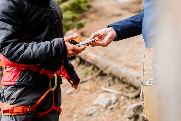Two climbers exchange essential gear before the climb. Collaboration and trust are key in every climbing adventure